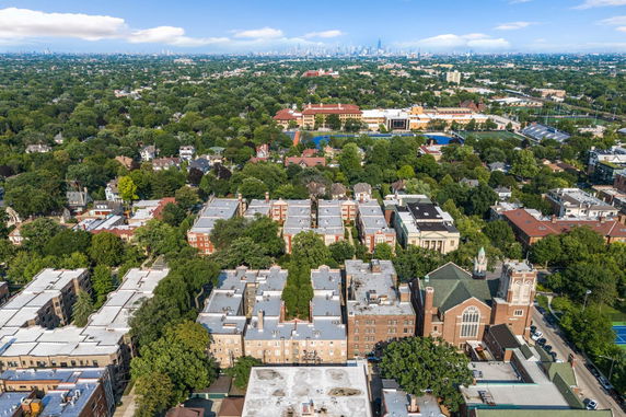 Panoramic aerial view of a suburban area with multiple buildings and greenery.
