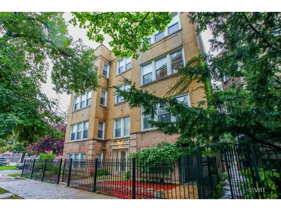Front view of a multi-story apartment building with brick exterior.