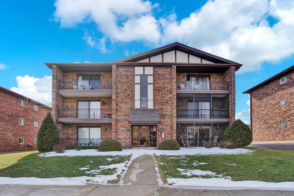 Front view of a multi-story brick building with balconies.