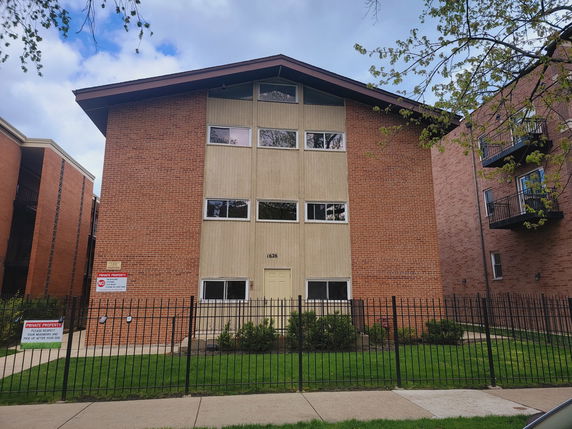Front view of a multi-story brick apartment building.
