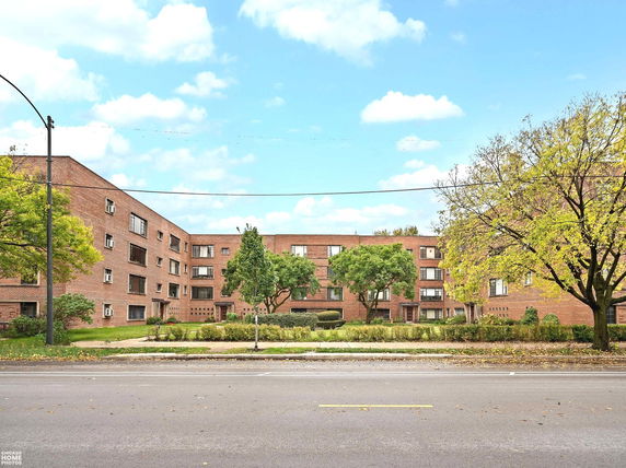Front view of a multi-story brick apartment building.