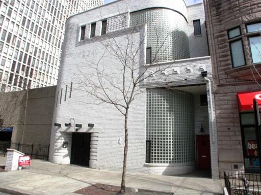 Front view of a multi-story building with unique cylindrical glass brick features.