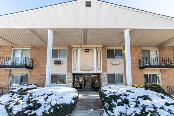 Front view of a two-story brick building with white columns.