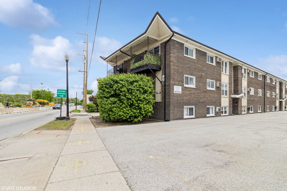 View of a three-story brick apartment building.