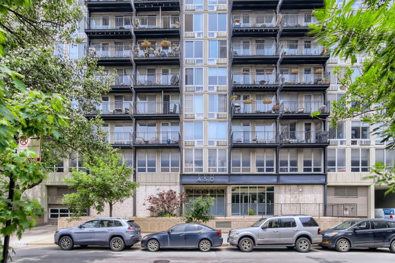 Front view of a multi-story apartment building with balconies.