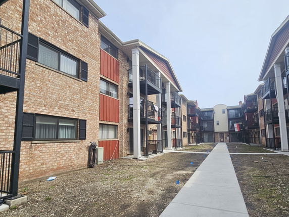 Front view of a multi-story apartment building with balconies.