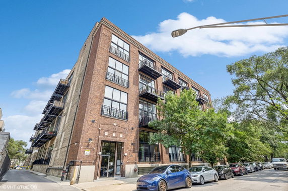 Front view of a multi-story brick building with balconies.