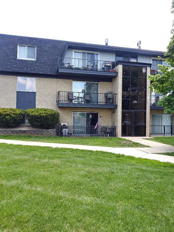 Front view of a multi-story apartment building with balconies.