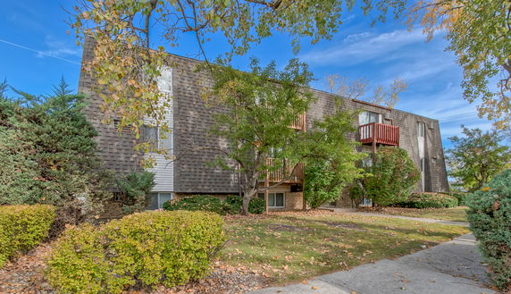 Front view of a multi-story apartment building with shingle exterior and balconies.