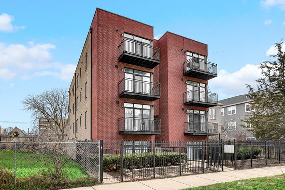Front view of a multi-story brick building with balconies.