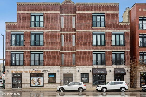 Front view of a multi-story brick commercial building with shops on the ground floor.