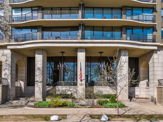 Front view of a multi-story building with large balconies and a formal entrance.