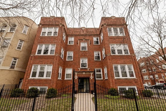 Front view of a brick multi-story residential building.