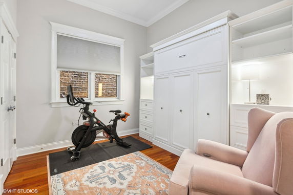 Indoor room featuring an exercise bike and built-in shelving.