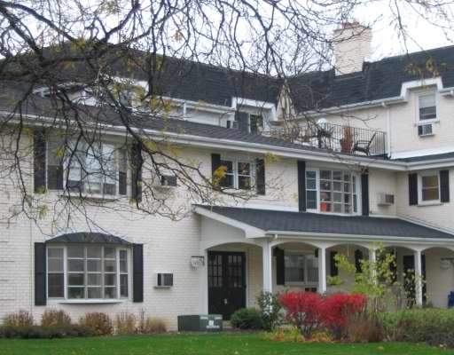 Front view of a multi-story house with a covered entrance and multiple windows.