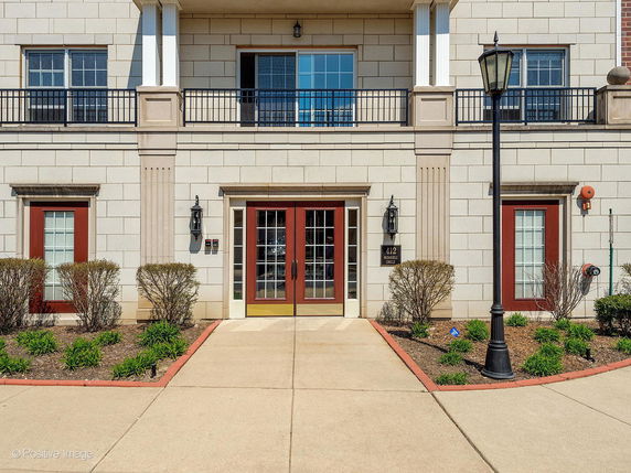 Front view of a multi-story building with a central entrance and two side windows.