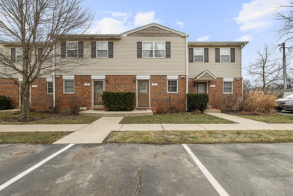 Front view of a two-story townhouse with brick and siding exterior.