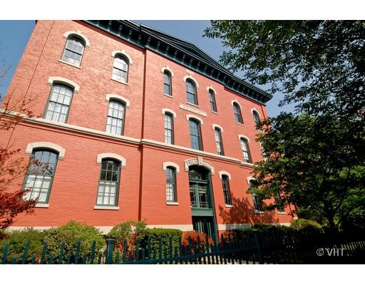 Front view of a four-story brick building with arched windows.