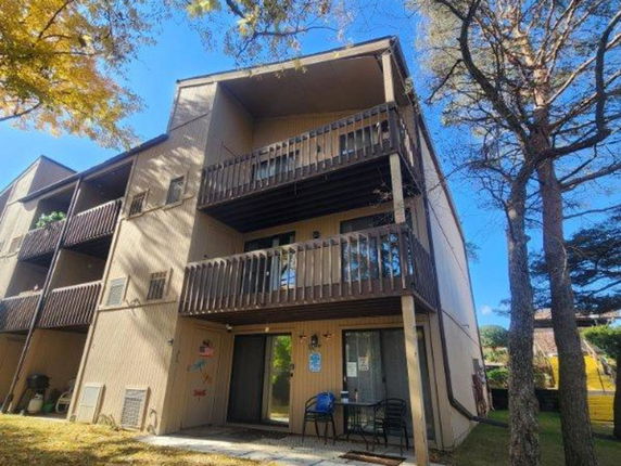 Front view of a three-story apartment building with balconies.