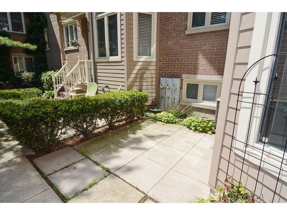 Backyard patio area with paved flooring and adjacent building.