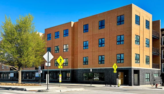 Front view of a modern two-story brick building on a street corner.