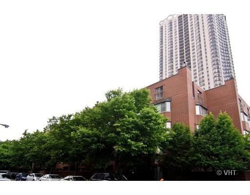 Front view of a tall residential building with large windows and a lower surrounding structure.
