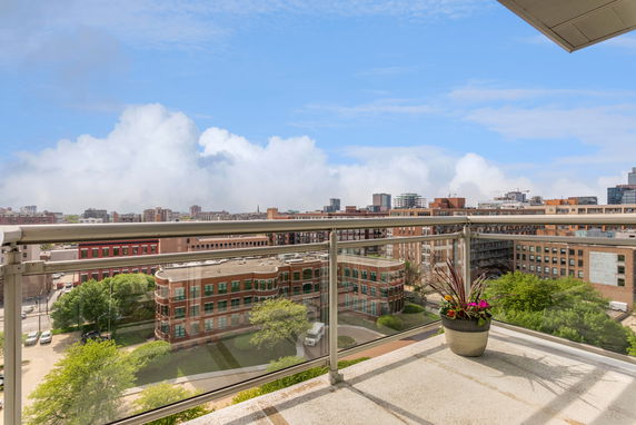 Panoramic view from a balcony overlooking city buildings and skyline.