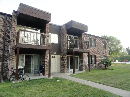 Front view of a two-story brick apartment building with balconies.