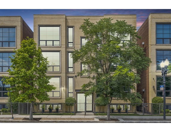Front view of a modern multi-story building with large windows.