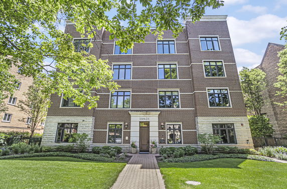 Front view of a multi-story brick building with large windows and a central entrance.