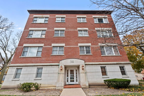 Front view of a multi-story brick building with white trim and entrance.