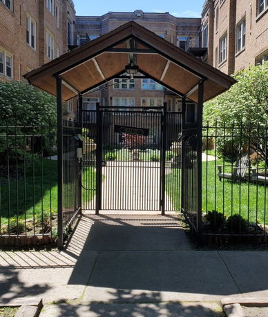 Front view of a brick residential building with gated entrance.