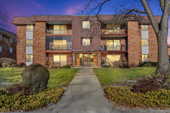 Front view of a multi-story brick building with balconies.
