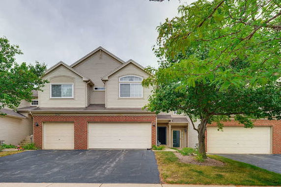 Front view of a two-story house with a double garage and brick facade.