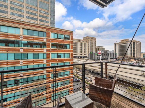 View from a balcony overlooking nearby buildings and roads.