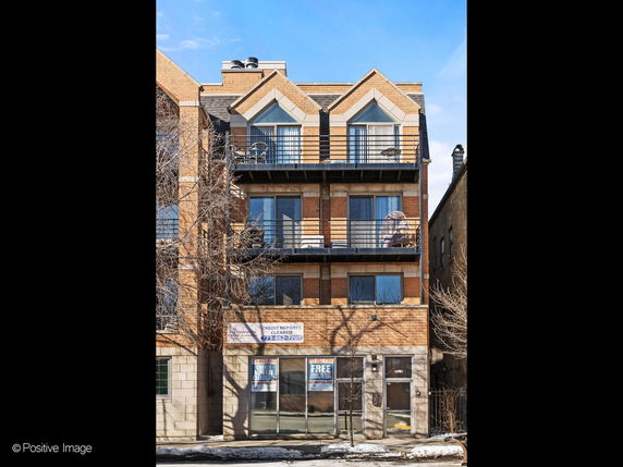 Front view of a multi-story brick building with balconies.