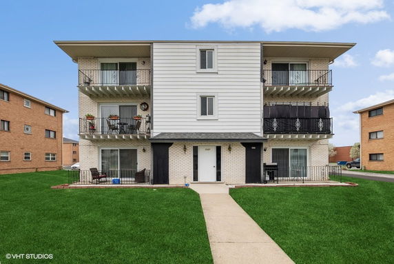 Front view of a three-story residential building with balconies.