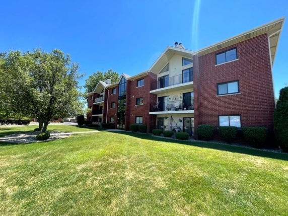 Front view of a multi-story apartment building with balconies.