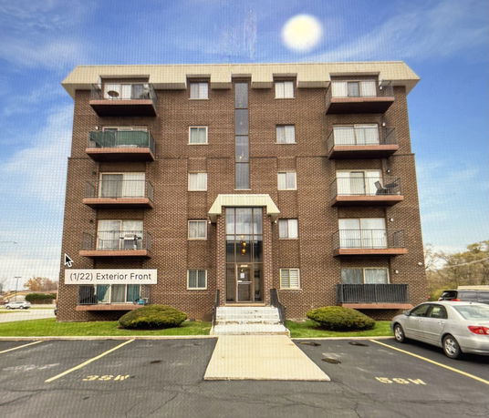Front view of a multi-story apartment building with balconies.