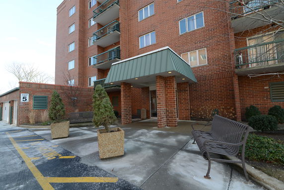 Front view of a multi-story brick building with a covered entrance.