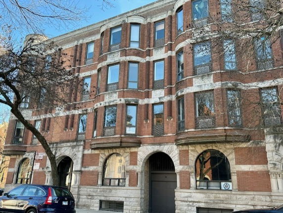 Front view of a multi-story brick building with arched windows.
