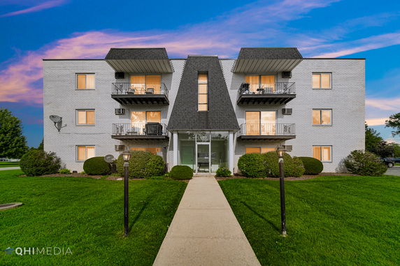 Front view of a three-story apartment building with balconies.