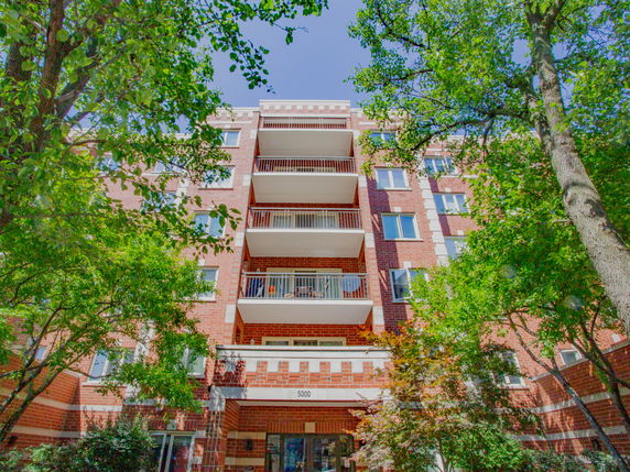 Front view of a multi-story apartment building with balconies.