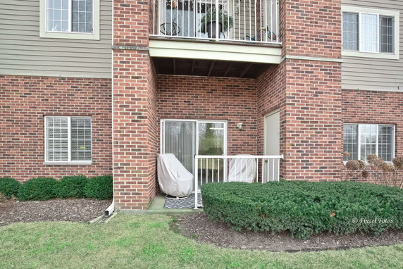 Front view of a multi-level brick building with balconies and windows.