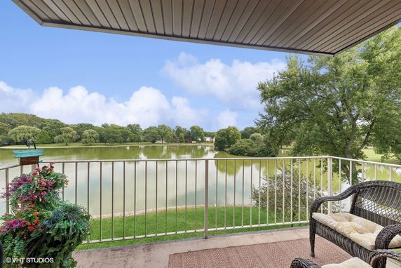 View of a lake and trees seen from a sheltered balcony.