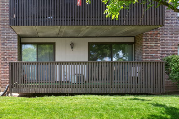 Front view of a building balcony with a wooden railing.
