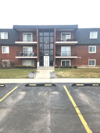 Front view of a three-story apartment building with balconies.