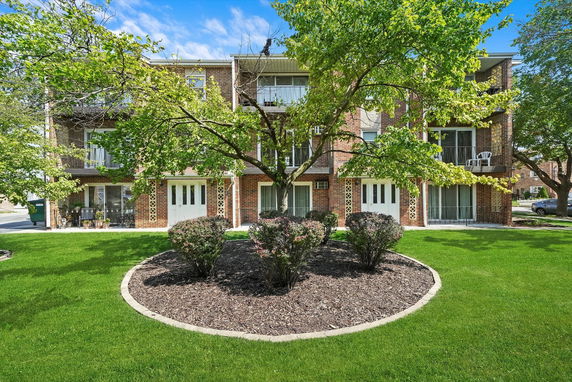 Front view of a three-story apartment building with balconies.
