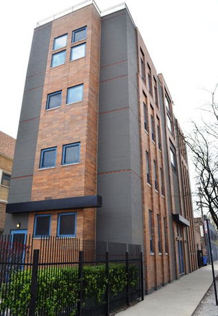 Front view of a multi-story building with a brick facade.