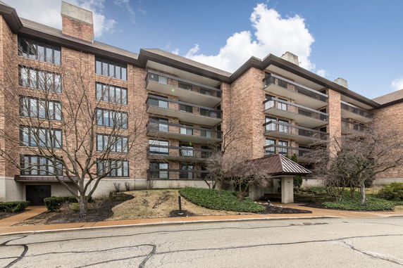 Front view of a multi-story brick building with balconies.